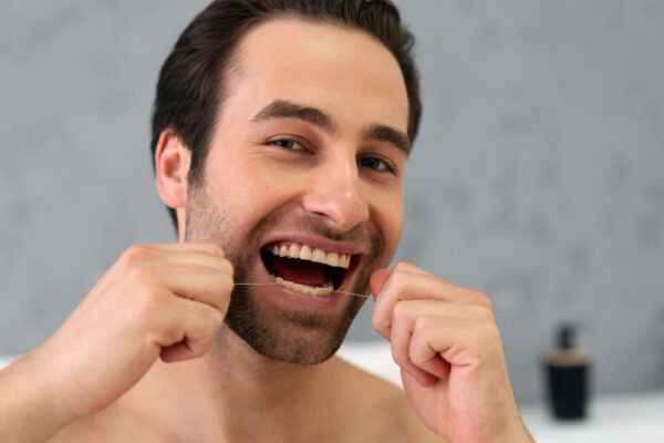 man-doing-flossing-for-cleaning-teeth