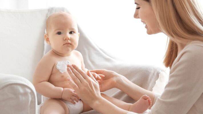 mom-with-baby-doing-moisturizing-cream-massage